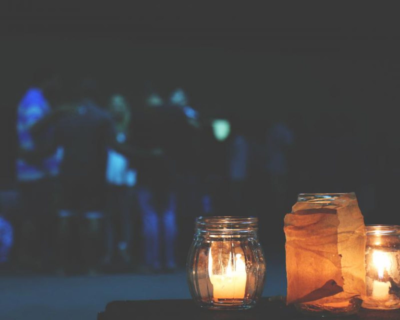 Candle jars glowing against a dark background