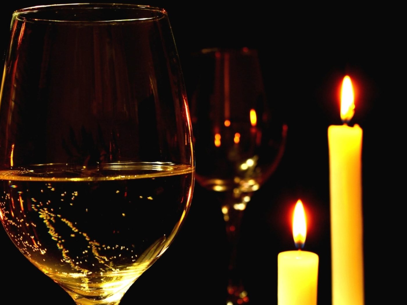 A glass of champagne beside candlelight