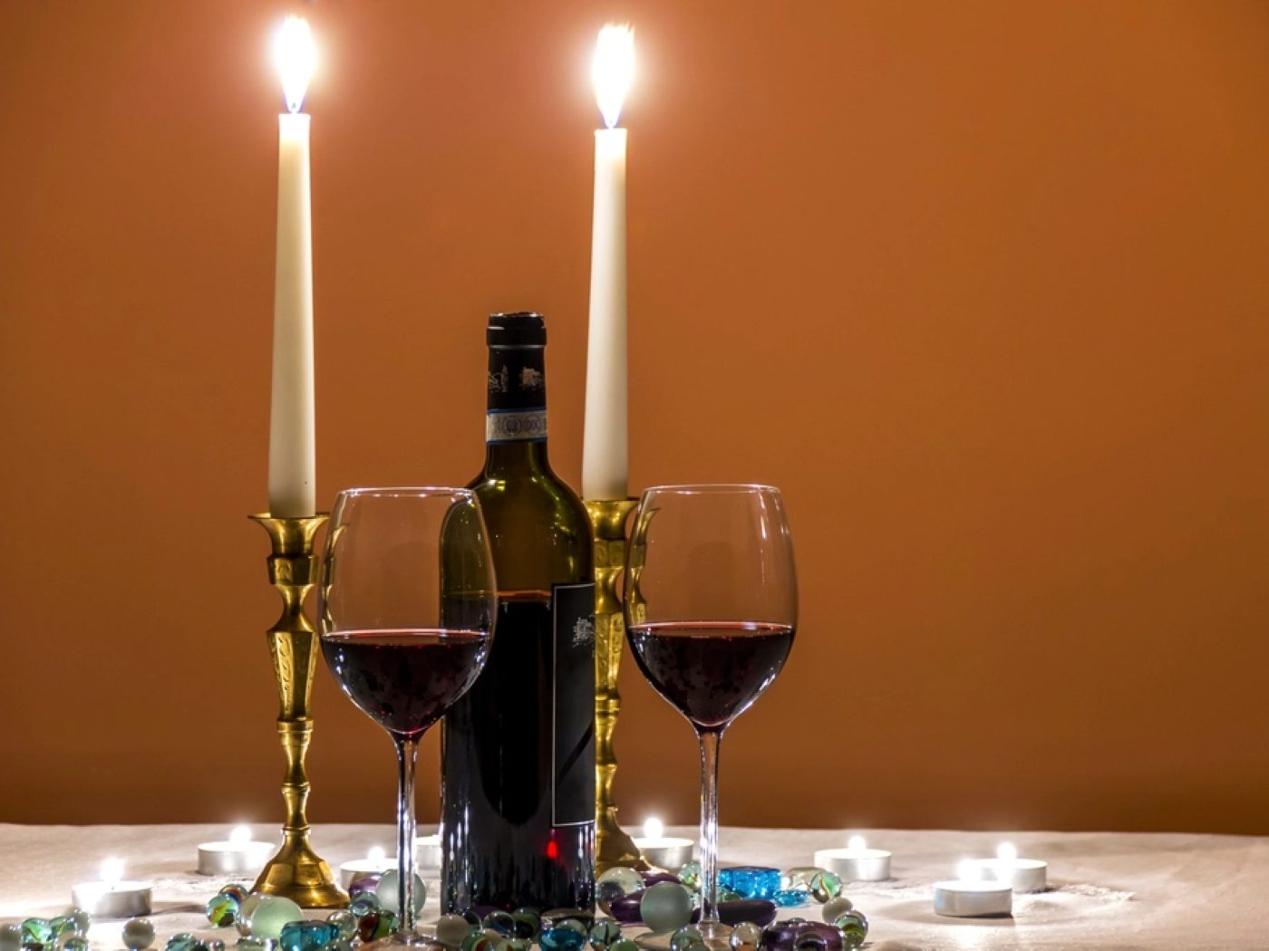 Wine glasses and candles set on a table for two