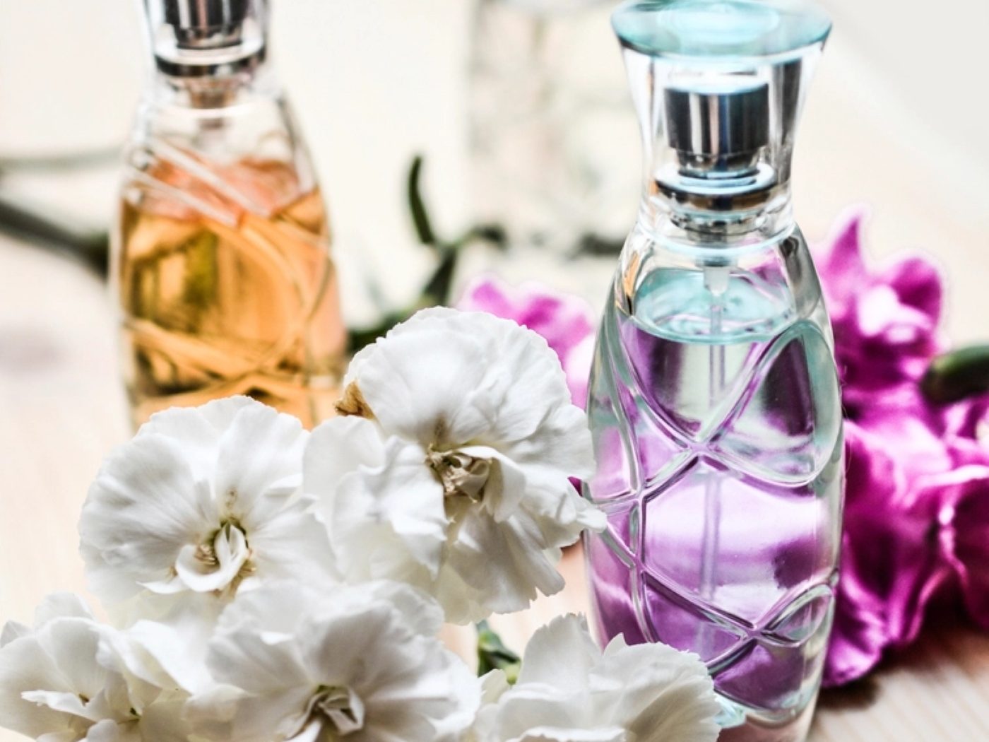 Fragrance bottles arranged with fresh flowers