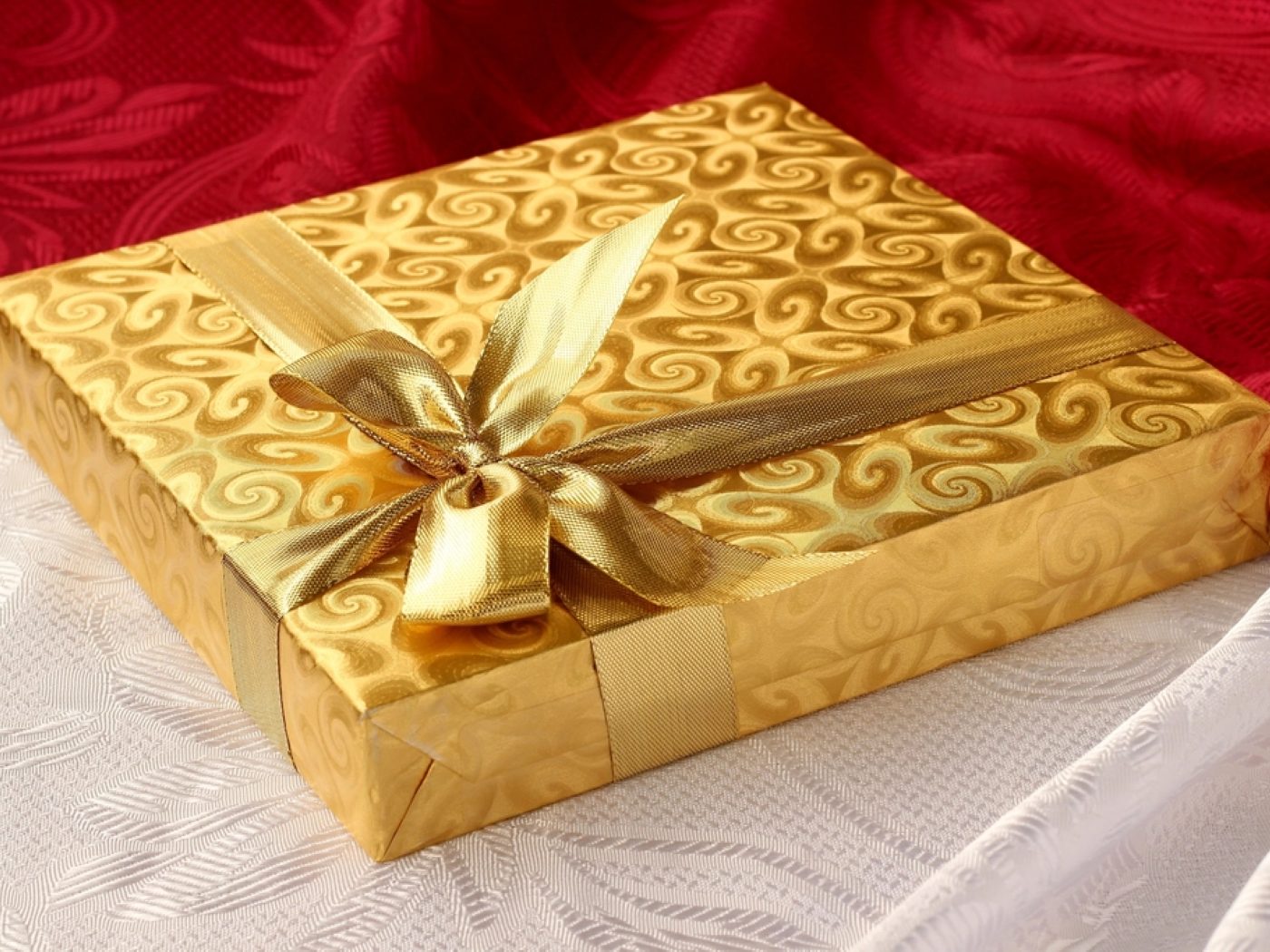 A gold gift box finished with a ribbon