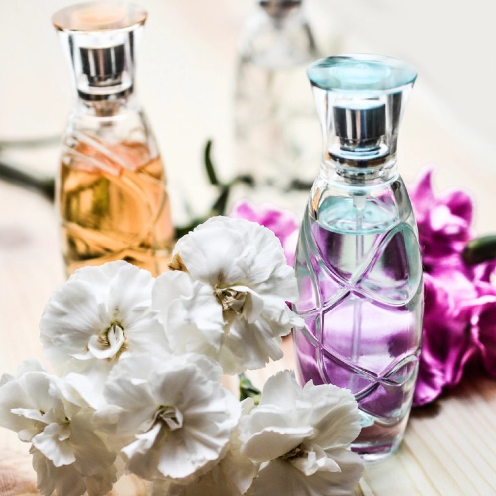 Fragrance bottles arranged with fresh flowers