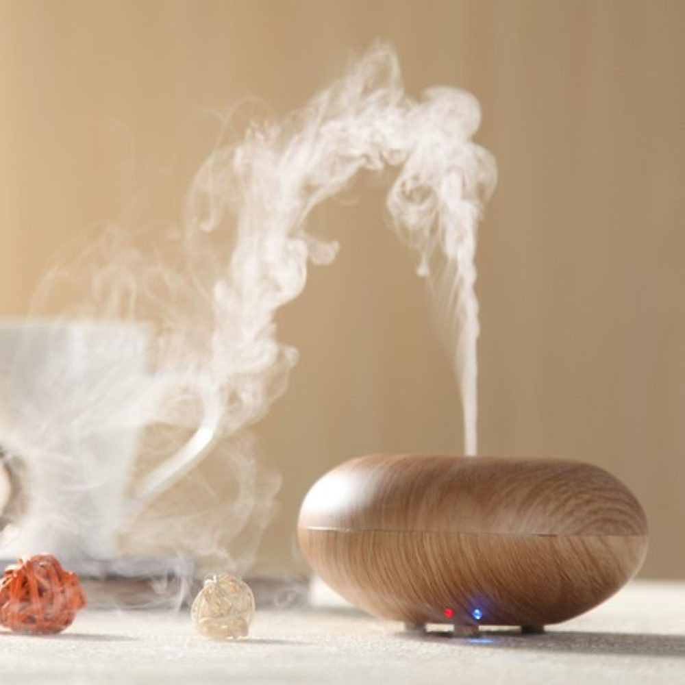 A wooden reed diffuser releasing a fine mist