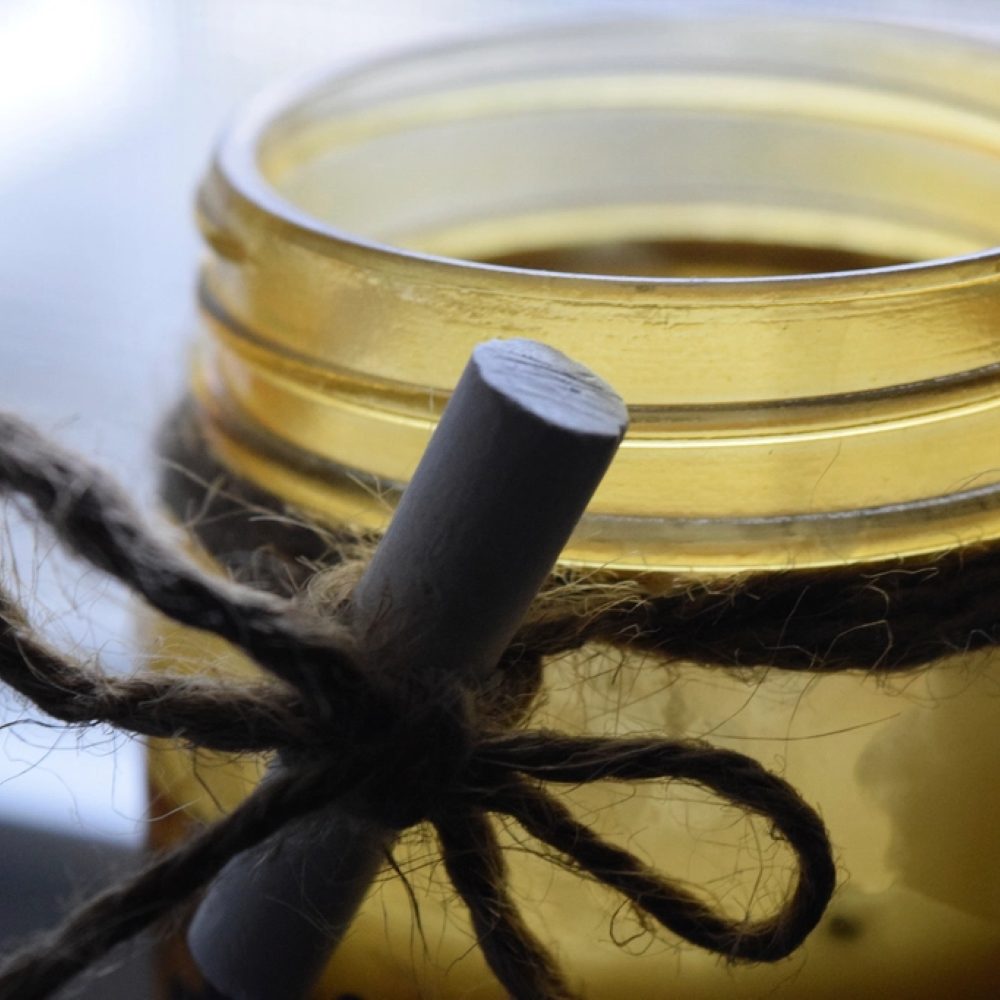 An amber glass candle tied with twine