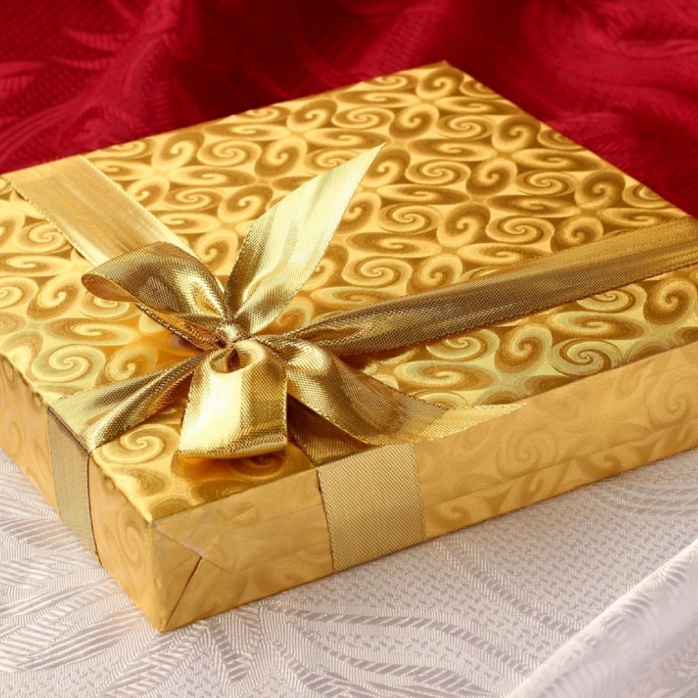 A gold gift box finished with a ribbon